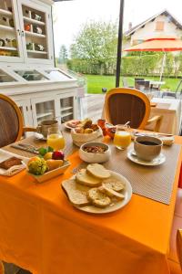 una mesa con alimentos para el desayuno y naranjas en ella en Hôtel Auberge de Chavannes, en Courlans