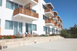 Una hilera de edificios de apartamentos con sillas y balcones. en San Agustin Paracas, en Paracas