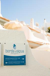a sign for a hotel in front of a building at Apartamentos Borda D´Agua in Albufeira