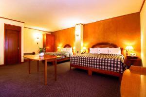 een hotelkamer met twee bedden en een tafel bij Hotel Lastra in Puebla +29 foto's