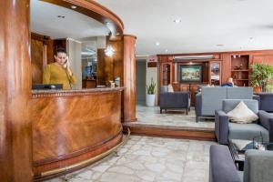 a man standing at a bar in a hotel lobby at Grand Hotel Americano in Machala