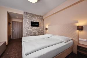 A bed or beds in a room at Hotel Studničky