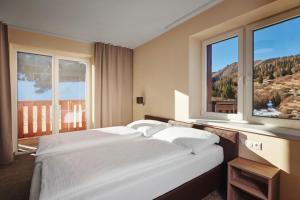 A bed or beds in a room at Hotel Studničky