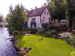 a house sitting next to a river with a yard at Lossi 8 Põltsamaa Erika in Põltsamaa