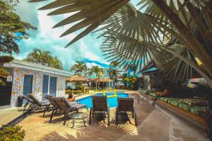 a pool at a resort with chairs and a table at Selina La Fortuna in Fortuna