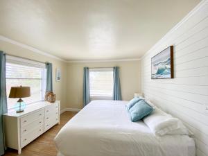 a white bedroom with a bed and a window at Molloy Gulf Motel & Cottages in St. Pete Beach