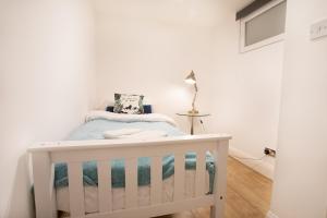 a small white crib in a white room at Rest & Recharge in the Northern Quarter in Manchester
