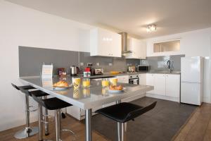 a kitchen with a large counter with chairs and appliances at Rest & Recharge in the Northern Quarter in Manchester