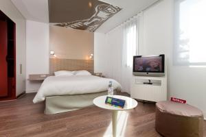 a bedroom with a bed and a television at ibis Styles Lille Aéroport in Lesquin