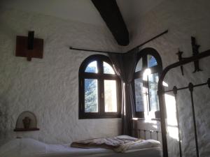 a bedroom with a bed and two windows at L'abri la Vall in Sorède