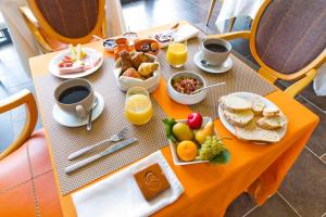 una mesa con desayuno y café. en Hôtel Auberge de Chavannes, en Courlans