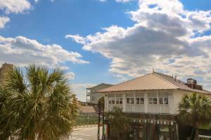a building with palm trees in front of a street at Shangri-La in Folly Beach