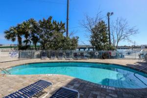 une petite piscine avec des chaises et une clôture dans l'établissement Turn of River Condo, à Folly Beach