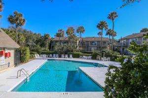 a swimming pool with palm trees and condos at Flip Flop Inn in Isle of Palms