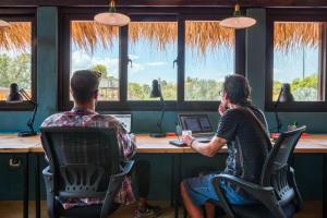 two people sitting at a desk in front of computers at Socialtel Atitlan in Panajachel