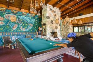 Ein Mann, der in einem Zimmer mit Billardtisch Billard spielt. in der Unterkunft Socialtel Atitlan in Panajachel