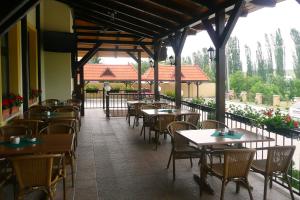 a restaurant with tables and chairs on a patio at Penzion Kastiel in Veľký Krtíš