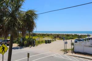 a palm tree in a parking lot next to the beach at Hang 6 in Folly Beach