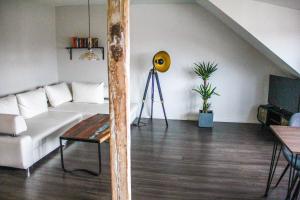 un salon avec un canapé blanc et une table dans l'établissement EXKLUSIVE 2 Zi. Dachgeschosswohnung in Top Lage!, à Brême