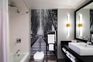 a bathroom with a bath tub and a bathroom with a wall mural at The Starling Atlanta Midtown, Curio Collection by Hilton in Atlanta