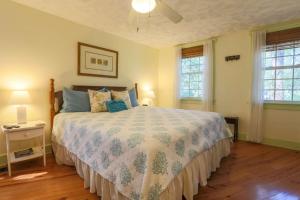 a bedroom with a bed and two windows at Shell Station House in Folly Beach