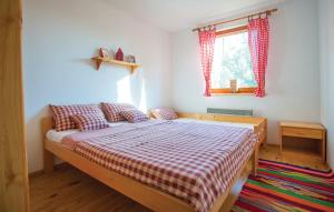 - une chambre avec un lit et une couverture en damier dans l'établissement KUĆA ZA ODMOR "DVA SRCA", à Čeminac