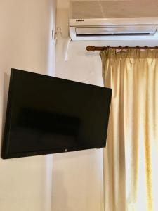 uma televisão de ecrã plano pendurada numa parede ao lado de uma janela em Teo's 2 persons Studio Deluxe B2 em Patra