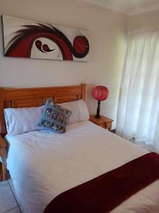 Stesh Margate Holiday House 12 Sleeper في مارغيت: غرفة نوم مع سرير أبيض كبير مع لوحة على الحائط
