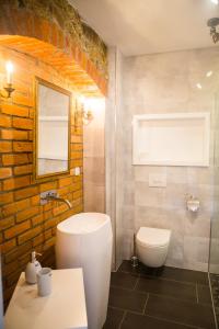 a bathroom with a white toilet and a sink at ApartOne Palais-Apartments in Bautzen