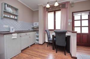 a kitchen with a table and two chairs and a counter at Guest House Romantika Panzio in Gyula