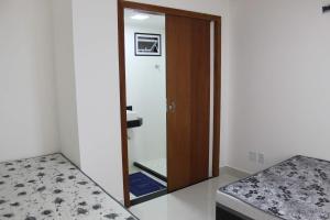 La salle de bains est pourvue d'un miroir et de toilettes. dans l'établissement Ap novo a 90m da praia, à Guarapari
