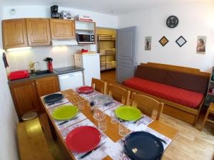 a kitchen and dining room with a table with plates on it at Au bon endroit N1 - Appartement 2 pièces 7 personnes - proche pistes - coeur station - balcon in Orcières