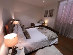 1 dormitorio con 1 cama y 1 mesa con lámpara en Chez Daisy en Longefoy