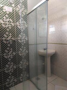 a bathroom with a glass shower and a sink at Hotel Porto Real in Pôrto Real