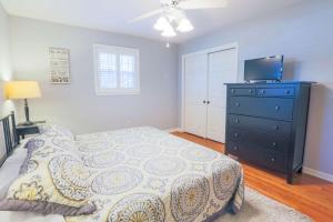 a bedroom with a bed and a dresser with a television at Oak Tree Manor in Charleston