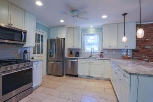 a kitchen with white cabinets and stainless steel appliances at Oak Tree Manor in Charleston