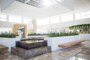 eine Lobby mit einem Brunnen, Bänken und Pflanzen in der Unterkunft Majestic Elegance Costa Mujeres - All Inclusive in Cancún