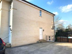 a building with a white door and a fence at Spacious 2 Bed Apartment With Off Street Parking in Bath