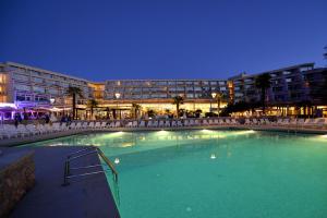 a large swimming pool in front of a building at night at Hotel Mediteran Plava Laguna in Poreč