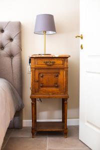 a nightstand with a lamp on it next to a bed at Het Hemelsveld in Hasselt +67 photos