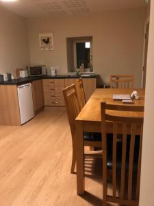 a kitchen with a wooden table and a table and chairs at Cornerstone 2 Bed Townhouse in Newtown-Dillon