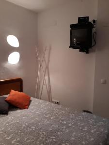um quarto com uma cama e uma televisão na parede em Casa Boneca - Aldeia das Açoteias em Albufeira