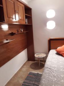 um pequeno quarto com uma cama e um pequeno banco em Casa Boneca - Aldeia das Açoteias em Albufeira