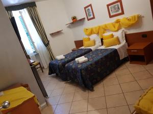 1 dormitorio con 2 camas y almohadas amarillas en Cavallo Bianco, en Novara