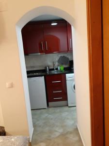 uma cozinha com armários vermelhos e electrodomésticos brancos em Casa Boneca - Aldeia das Açoteias em Albufeira