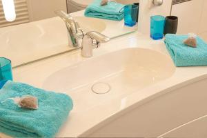 ein Waschbecken mit 2 Handtüchern und einem Spiegel in der Unterkunft Villa Wiederkehr Einkehr in Ostseebad Sellin