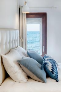 un mucchio di cuscini su un letto con finestra di Hostal Altea House ad Altea