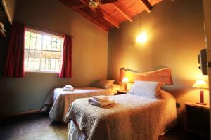 Un dormitorio con dos camas y una ventana. en Cabañas Atardeceres, en Capilla del Monte 77 fotos más