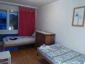 Kleines Zimmer mit 2 Betten und einer Kommode in der Unterkunft Calm Family Apartment in Bern