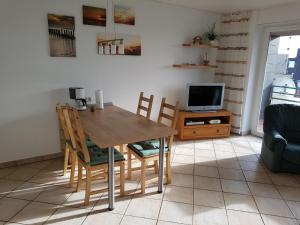 une salle à manger avec une table, des chaises et une télévision dans l'établissement Wangeroogeweg 5a, à Schillig